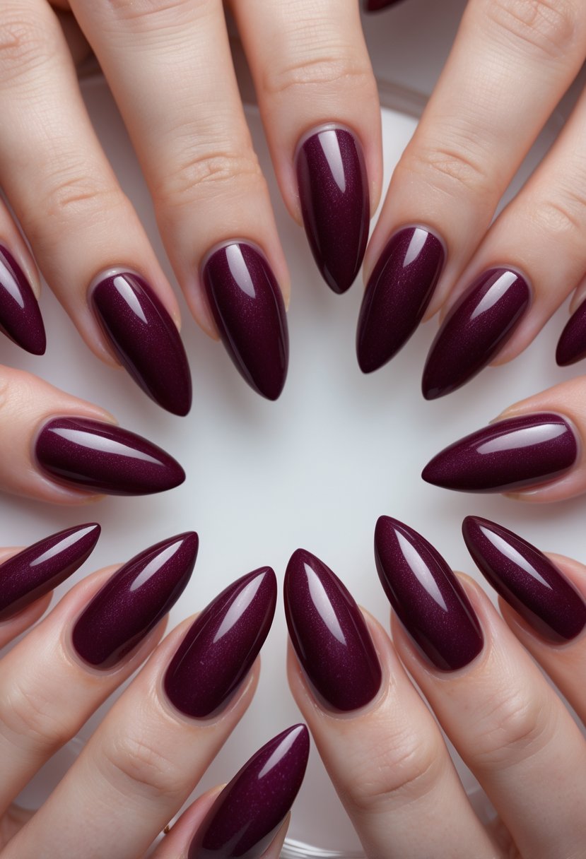 Close-up of hands with deep burgundy almond-shaped nails featuring a subtle shimmer.