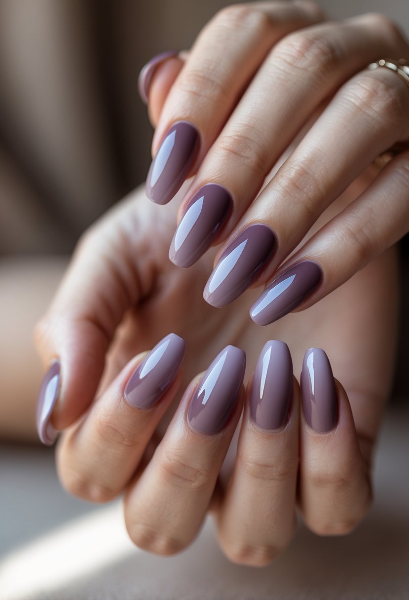 Close-up of hands with smoky mauve gradient nail polish on neatly manicured nails.