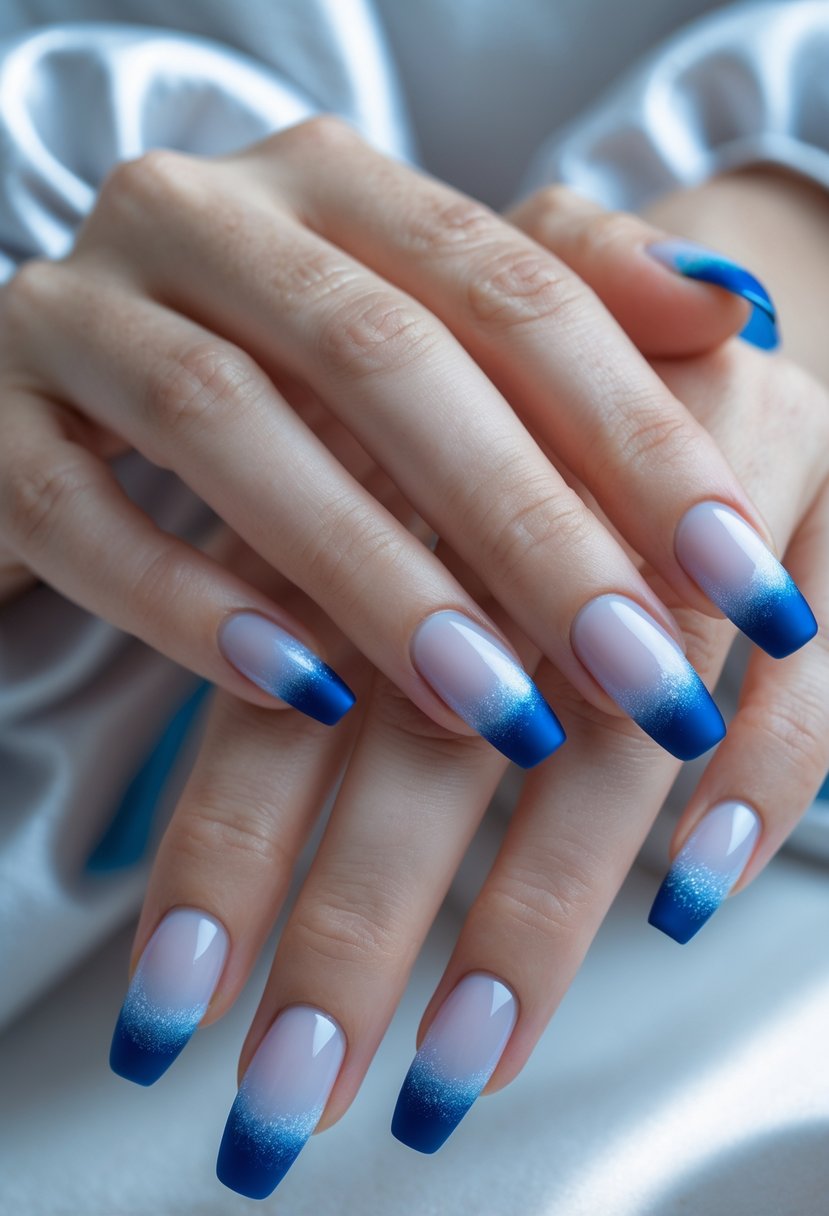 Close-up of hands with 18 nails painted in a gradient icy blue design with frosted tips.